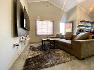 a living room with a couch and a table at Down Town Delight - 2BR Budget Retreat in Gaborone
