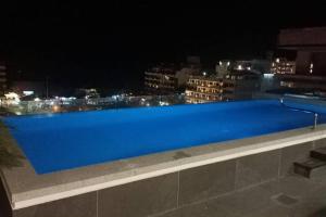 a blue pool on top of a building at night at Estudio de ensueño con alberca 303 in Puerto Vallarta