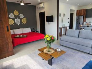 a living room with a red bed and a couch at Estudio de ensueño con alberca 303 in Puerto Vallarta