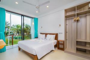 a bedroom with a bed and a large window at Kaas Villas - Entire Two Bedroom Villa With Private Pool & Garden in Dickwella