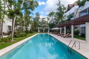 une piscine avec des chaises longues à côté d'un bâtiment dans l'établissement Luxury penthouse w-jacuzzi in the heart of Tulum, à Tulum