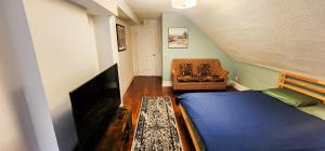 Un dormitorio pequeño con una cama y un televisor. en Heart of Toronto Home, en Toronto