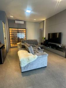 a living room with a couch and a flat screen tv at Casa alto padrão piscina aquecida in Joinville