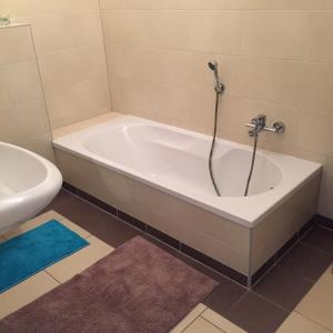 a bath tub with a shower in a bathroom at City FEWO Leipzig in Leipzig