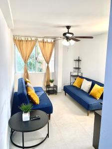 a living room with a blue couch and a table at Apartment Coral near Mamitas Beach in Playa del Carmen