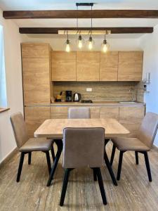 Una mesa de comedor con sillas y una cocina. en Villa Maslina, en Kolan