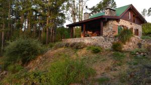 a stone house on a hill in the woods at Cabaña villa alpina Mantillo de bosque in Villa Alpina