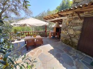 un patio con un tavolo e un ombrellone di Casa da Esperança a Lousã