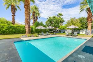 a swimming pool with chairs and palm trees at Home with Pool 1 Mi to Downtown Palm Springs! in Palm Springs