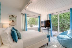a bedroom with a bed and a tv and a window at Home with Pool 1 Mi to Downtown Palm Springs! in Palm Springs