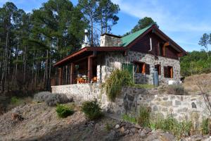 a stone house with a green roof at Cabaña villa alpina Mantillo de bosque in Villa Alpina