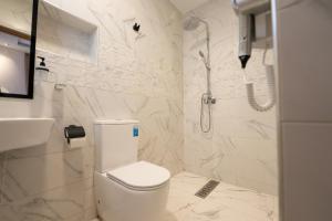 a white bathroom with a toilet and a shower at Residence Imsouane Surf Camp in Imsouane +60 photos