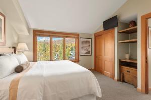 a bedroom with a large white bed and a window at Pinecone Perch Capitol Peak Lodge #3227 in Snowmass Village