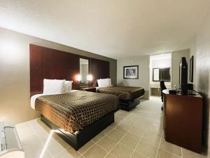 Una habitación de hotel con dos camas y un televisor de pantalla plana. en Budgetel Inn - Phenix City, en Phenix City
