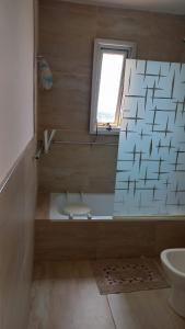 a bathroom with a tub and a toilet and a window at Balcón del Paraná in Corrientes +7 photos