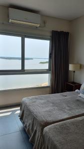 a bedroom with a bed and a large window at Balcón del Paraná in Corrientes