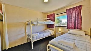 ein Schlafzimmer mit zwei Etagenbetten und einem Fenster in der Unterkunft Riverview Holiday Apartment 54 - Kalbarri WA in Kalbarri