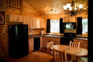 a kitchen with a table and a black refrigerator at Cole Cabins in Deadwood