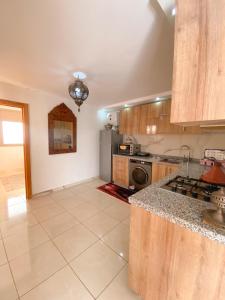 a kitchen with a stove and a refrigerator at Deluxe Apartment At Amouage Anza in Agadir