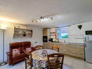 a kitchen and dining room with a table and a couch at Évasion nature en Brenne : maison avec jardin, activités et économie près de Châteauroux - FR-1-591-58 in Luant