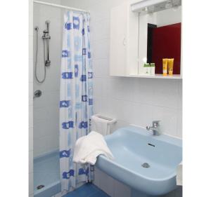 ein Badezimmer mit einem blauen Waschbecken und einer Dusche in der Unterkunft A Modo Mio B&B in Monopoli