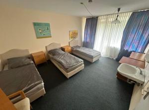 una camera con tre letti e un lavandino e un bagno di Turp Residenz a Blomberg Altre 10 foto