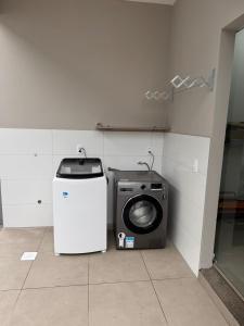 a washing machine and a washer in a room at casa canasvieiras 100 m praia in Florianópolis