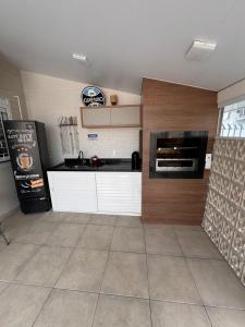a kitchen with a sink and a stove top oven at casa canasvieiras 100 m praia in Florianópolis