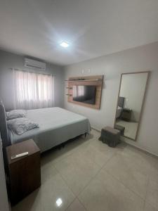 a bedroom with a bed and a large mirror at casa canasvieiras 100 m praia in Florianópolis