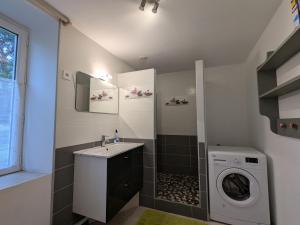 a bathroom with a sink and a washing machine at Évasion nature en Brenne : maison avec jardin, activités et économie près de Châteauroux - FR-1-591-58 in Luant