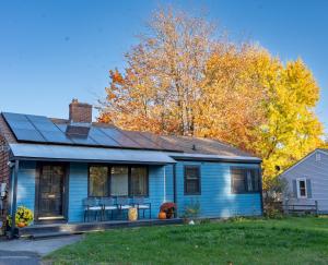 a blue house with chairs in the front yard at Air Vermont Apartment in South Burlington