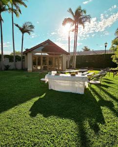 a white table in a yard with palm trees at Alquiler temporario Quincho in Reconquista