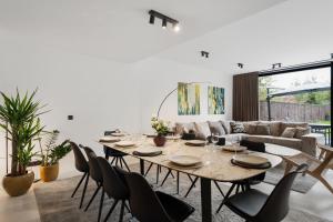 a dining room with a table and chairs and a couch at Modern & Spacious House with Wellness in Kortrijk