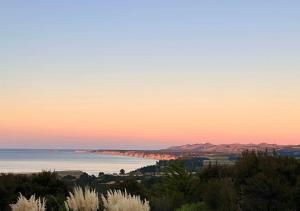a view of the ocean at sunset at Korimako PurePod in Tormore +4 photos