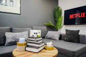 a pile of books on a coffee table in a living room at Bienvenue dans votre havre de paix à Griffintown in Montréal