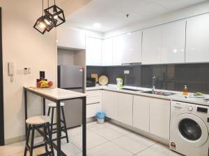 a kitchen with white cabinets and a washing machine at Almas Suites Poolview Netflix 100mbps BySTAY in Nusajaya