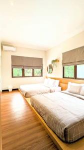 une chambre avec deux lits et deux fenêtres dans l'établissement Cottonwood Villa Rotensia BBQ Pool Pingpong, à Bandung 23 autres photos