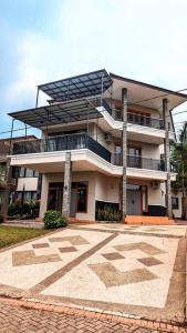 un grand bâtiment avec un balcon au-dessus dans l'établissement Cottonwood Villa Rotensia BBQ Pool Pingpong, à Bandung