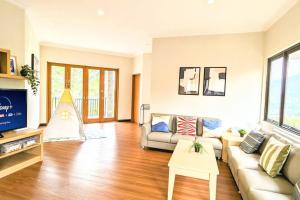 un salon avec un canapé et une télévision dans l'établissement Cottonwood Villa Rotensia BBQ Pool Pingpong, à Bandung