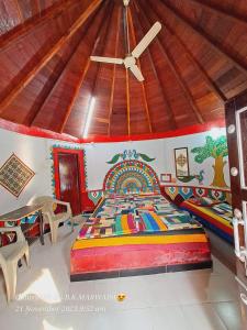 a bedroom with a colorful bed with a ceiling at Rann bhumi village resort in Bherandiāla +68 photos