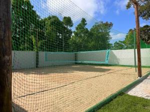 einen Tennisplatz mit einem Netz darüber in der Unterkunft Casa para temporada em Arraial D'ajuda in Porto Seguro