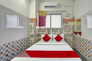 a bedroom with a bed with red pillows at Hotel O RKR Residency in Chennai