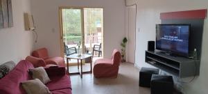 un salon avec un canapé et une télévision à écran plat dans l'établissement Corrientes Grand Apart, à Corrientes