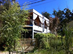 a white house with a fence in front of it at La Pedrasanta in La Pedrera