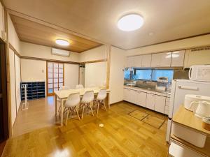 eine Küche mit Tisch und Stühlen in einem Zimmer in der Unterkunft ファミリー仲良しグループ向け一棟貸切の宿ともだちハウス in Chichibu