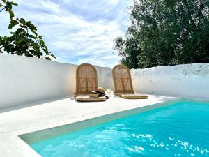2 sillas sentadas junto a una piscina en Casa Valentina, en Pedrógão