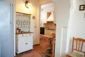 a kitchen with a table and a white refrigerator at Il Casolare Degli Ulivi in Oria