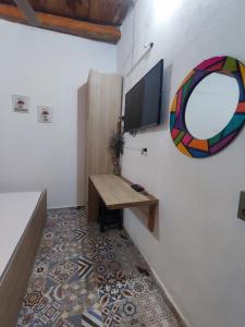 a room with a table and a tv on a wall at Hostal Casablanca in San Gil