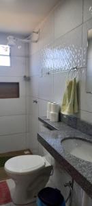 a bathroom with a white toilet and a sink at Flat do Sossego 2 in Triunfo +10 photos