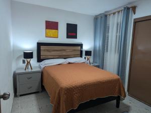 a bedroom with a bed and two night stands with lamps at Barcena in Durango